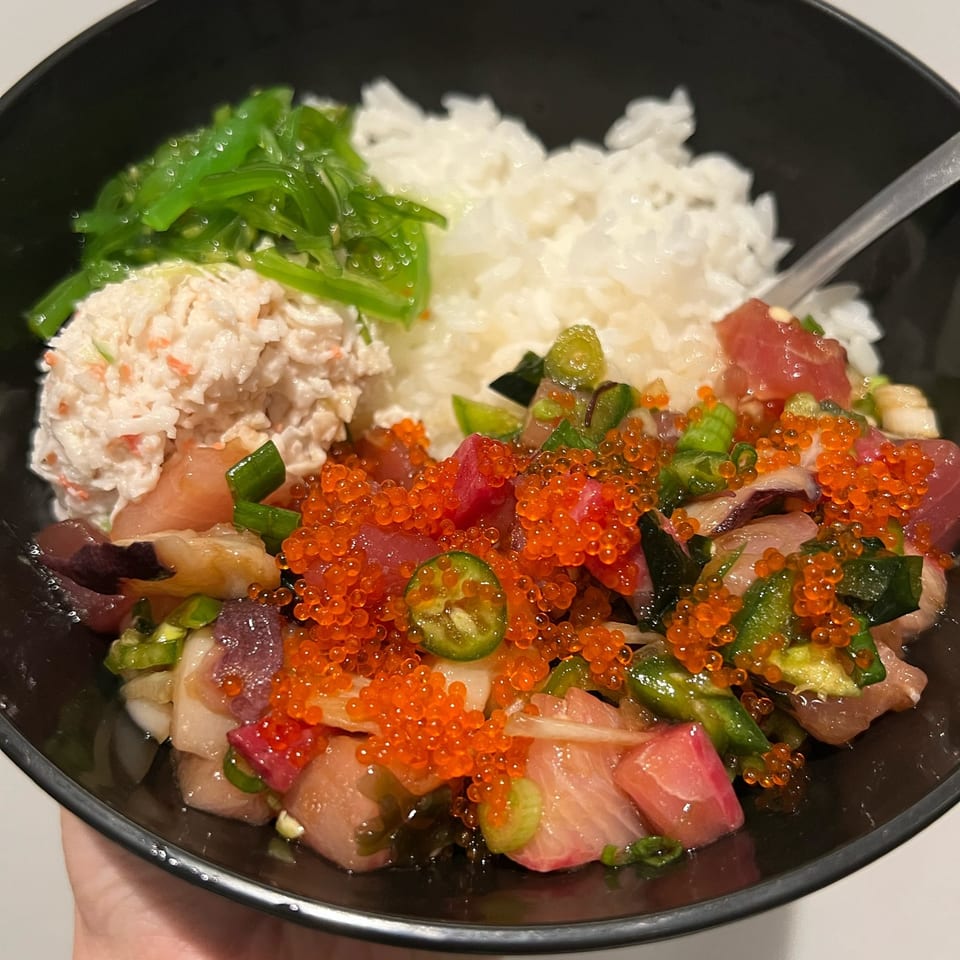 A Benicia Poke Co. poke bowl with rice, seaweed salad, crab salad, fish, roe, and jalapenos.